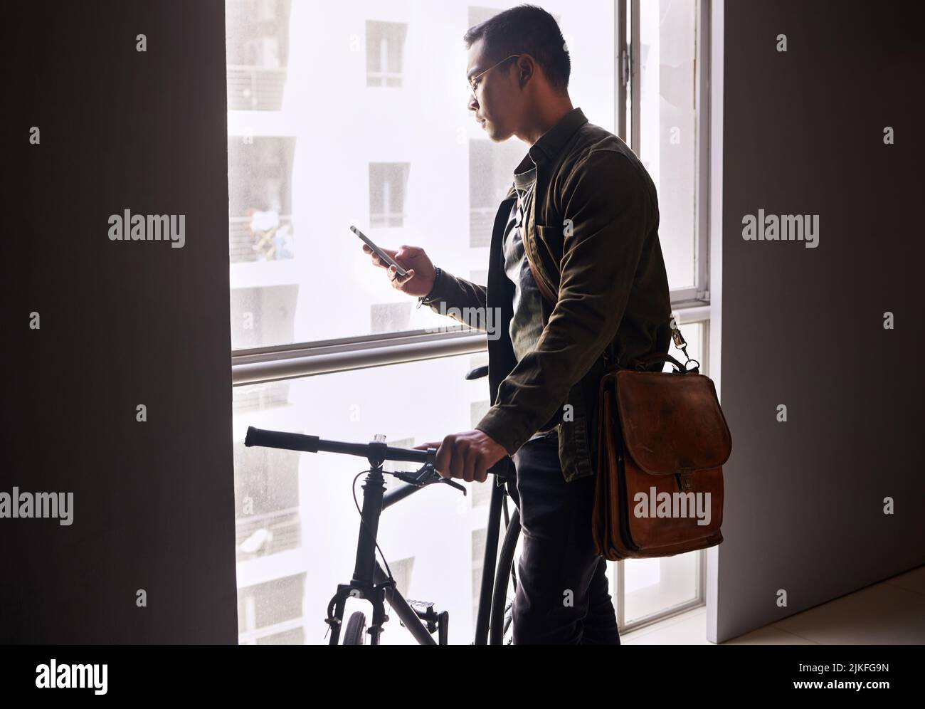 Technologie für unterwegs. Schoss einen jungen Mann mit einem Telefon vor einem städtischen Hintergrund. Stockfoto