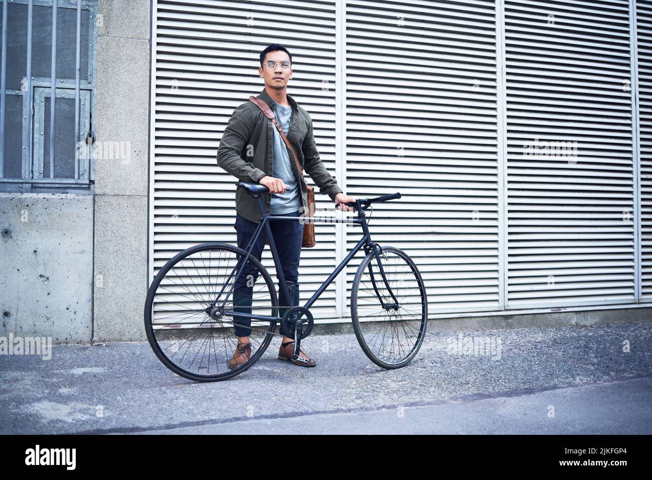 Ich stehe hier mitten im Nirgendwo. Ein junger Mann posiert mit einem Fahrrad in der Stadt. Stockfoto