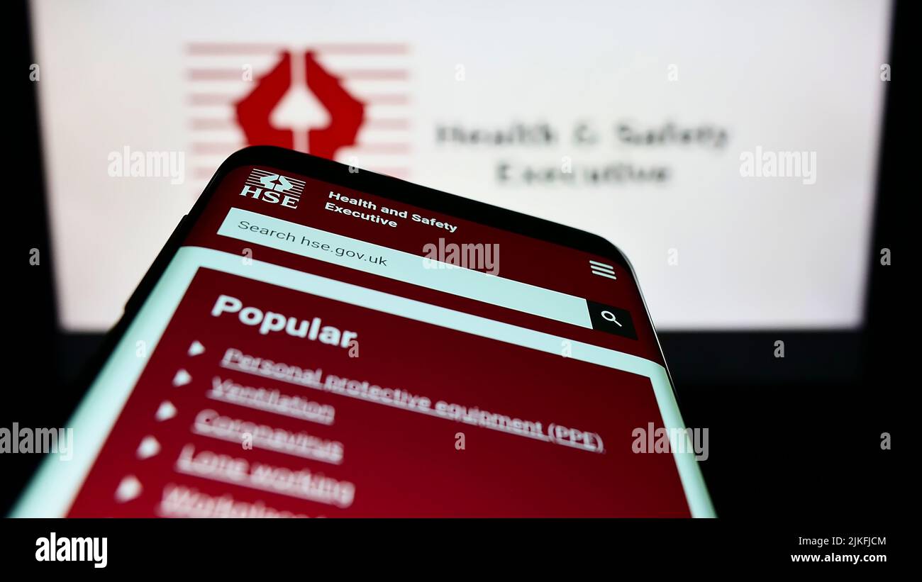 Smartphone mit der Webseite der britischen Agentur Health and Safety Executive (HSE) auf dem Bildschirm vor dem Logo. Konzentrieren Sie sich auf die obere linke Seite des Telefondisplays. Stockfoto