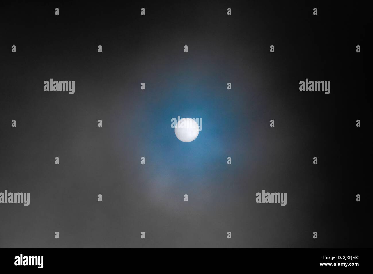 Blick auf die weiße Sonne durch den Nebel und die Wolken Stockfoto