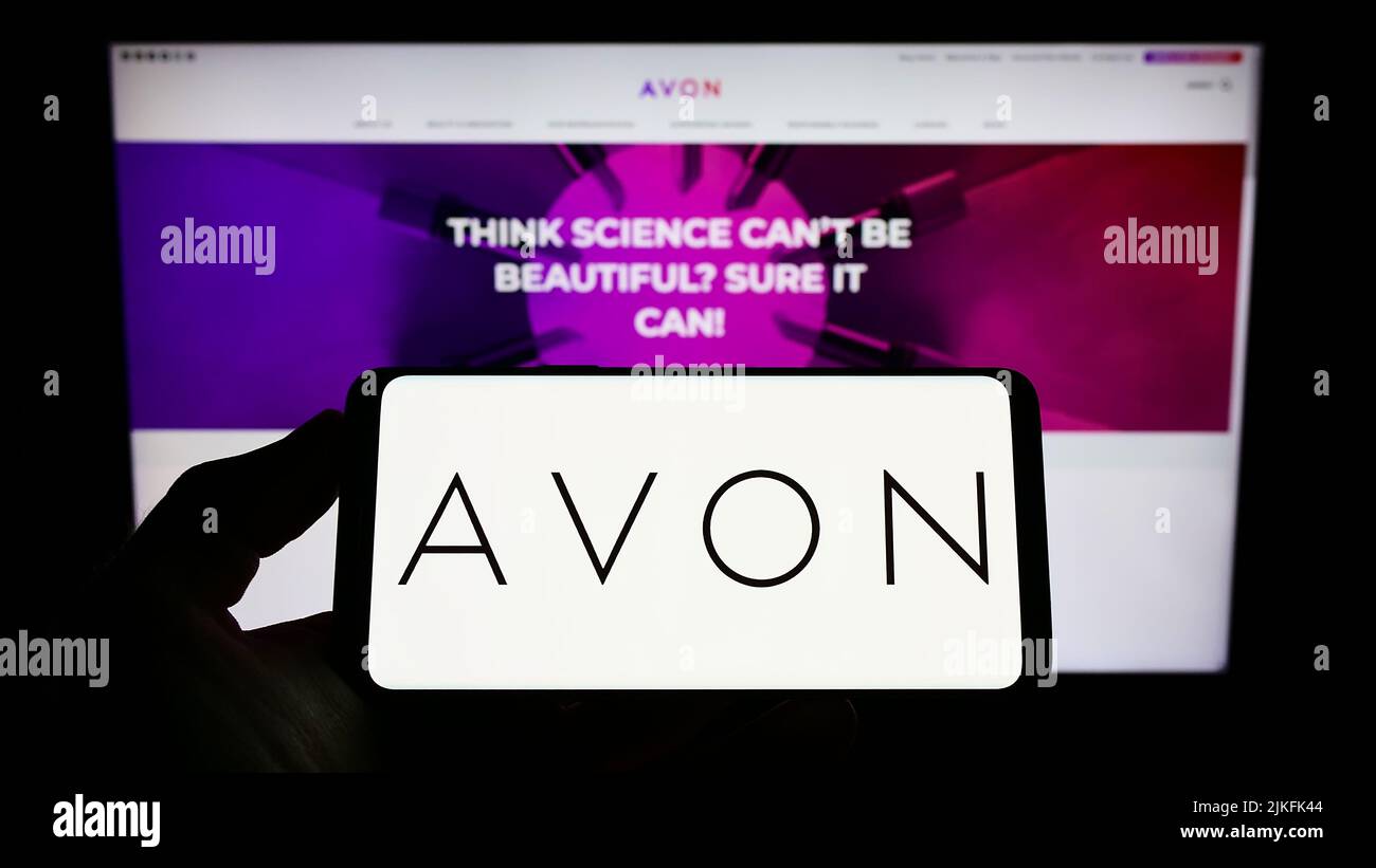 Person, die das Smartphone mit dem Logo des Kosmetikunternehmens Avon Products Inc. Auf dem Bildschirm vor der Website hält. Konzentrieren Sie sich auf die Telefonanzeige. Stockfoto
