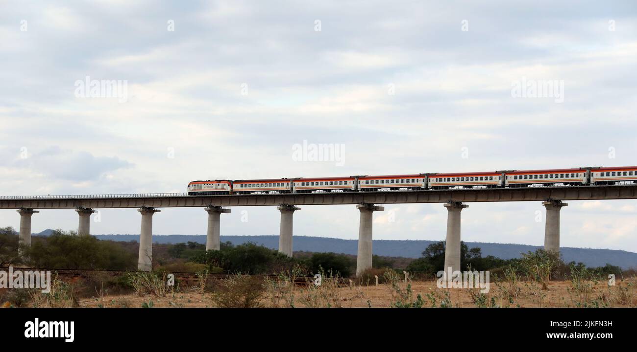 (220802) -- NAIROBI, 2. August 2022 (Xinhua) -- Ein Personenzug fährt am 28. Juli 2022 auf der Super Major Bridge des Tsavo River in der Nähe des Tsavo National Park in Kenia. Die in China gebaute Mombasa-Nairobi Standard Gauge Railway (SGR) hat gerade ihr fünftes Jubiläum des sicheren Betriebs gefeiert. Die Mombasa-Nairobi Railway führt durch Naturschutzgebiete wie den Nairobi National Park und den Tsavo National Park. Um die Auswirkungen auf die Umwelt zu reduzieren, wurden bei der Planung und dem Bau der Eisenbahn eine Reihe von Maßnahmen ergriffen, wie die Umgehung der Mangroven, die dazu beitragen, die mang zu halten Stockfoto