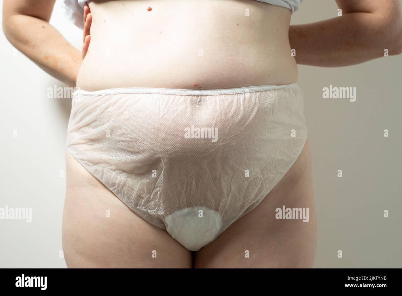 Weiblicher postpartaler Bauch in Einweg-Unterhosen, Hygiene Stockfoto