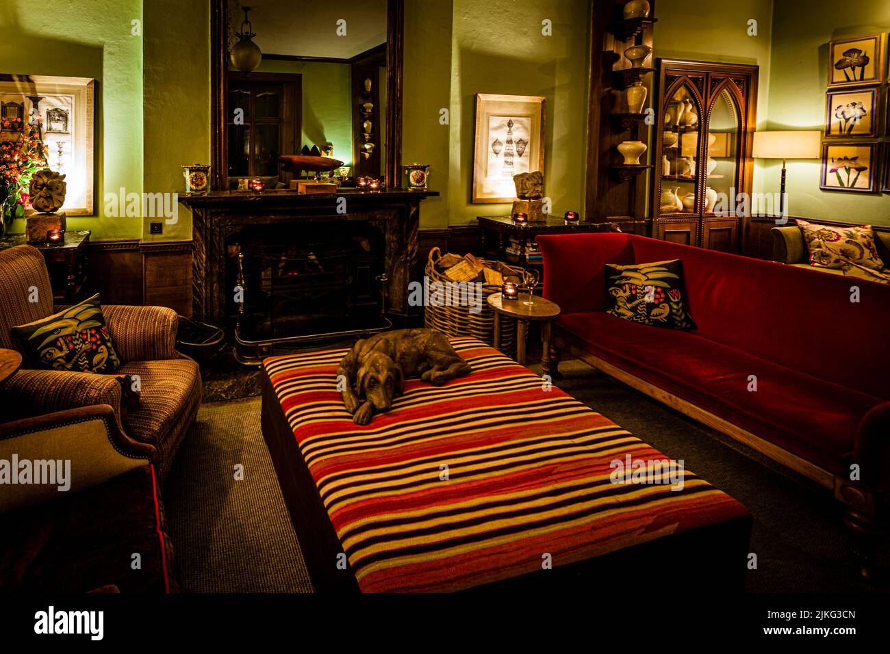 Der Salon im Endleigh Hotel mit wunderbaren Sitzmöglichkeiten sowie einem Kamin und dekorativem Holzhund Stockfoto