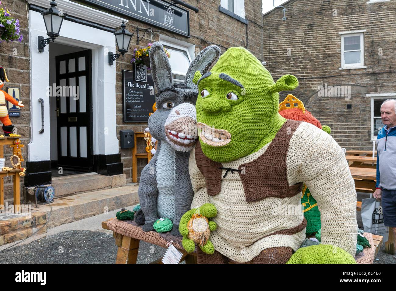 Hawes Village in den Yorkshire Dales, lebensgroße gestrickte Shrek-Charaktere, die für wohltätige Spendenaktionen außerhalb des Board Inn, Yorkshire, England, angezeigt werden Stockfoto