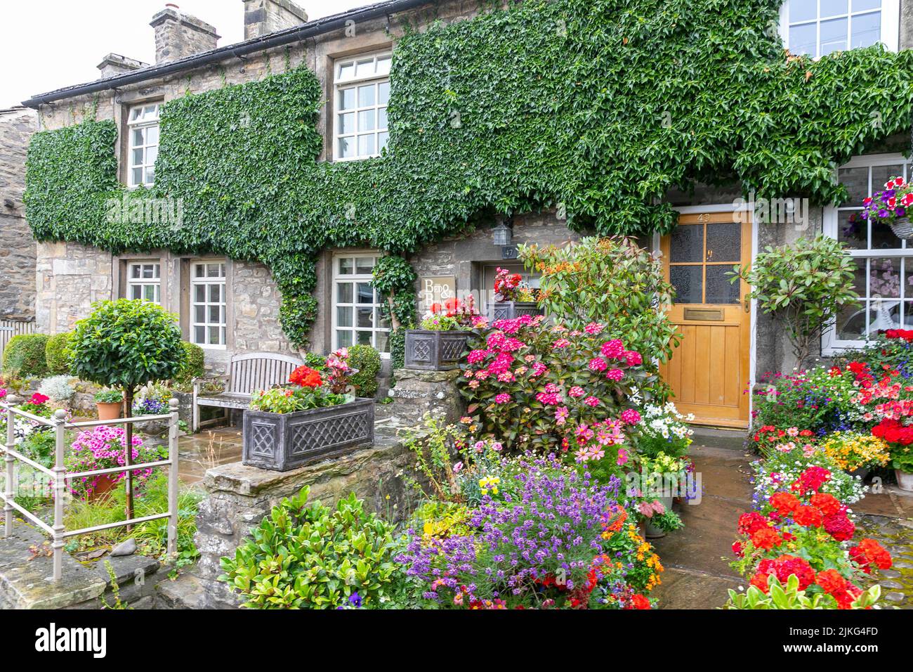 Dorf Grassington in den Yorkshire Dales und Hüttengarten mit blühenden Sträuchern in einem Gästehaus Cottage im Dorf, Yorkshire, England, Großbritannien Stockfoto