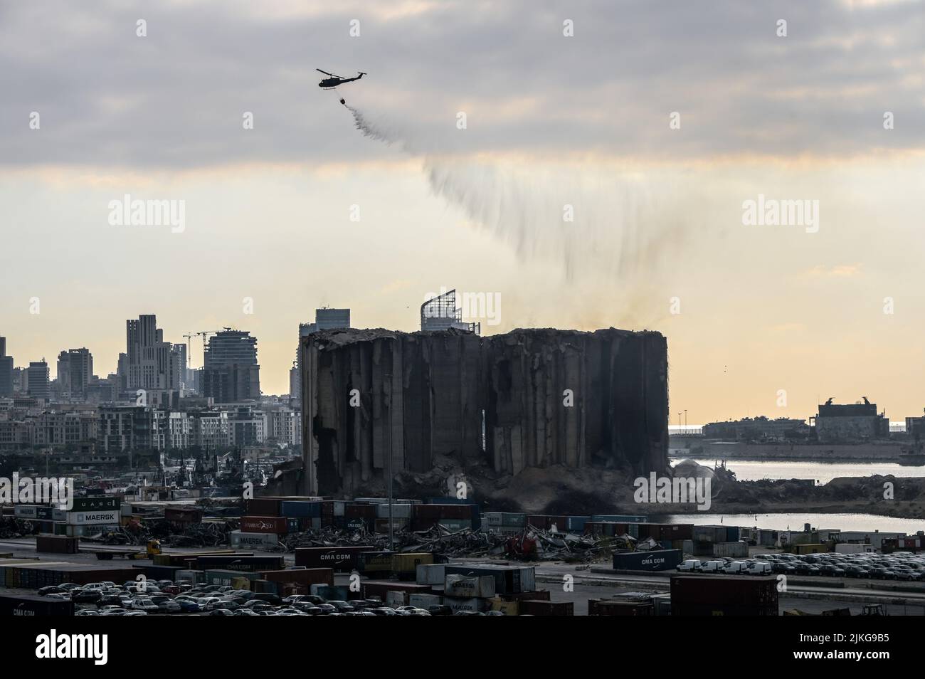 Beirut, Libanon, 31. Juli 2022. Wasserhubschrauber entfachen die schwelende Ruine der Getreidesilos im Hafen von Beirut. Das fermentierende Getreide brannte über zwei Wochen in den Silos, die vor zwei Jahren bei der Explosion des Beirut Port am 4. August 2020 schwer beschädigt wurden, bevor zwei Silos aus dem Nordblock der instabilen Struktur zusammenbrachen. Stockfoto