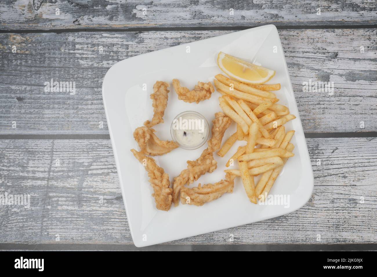 Knuspriger frittierter Tintenfisch-Stick und pommes auf dem Tisch Stockfoto