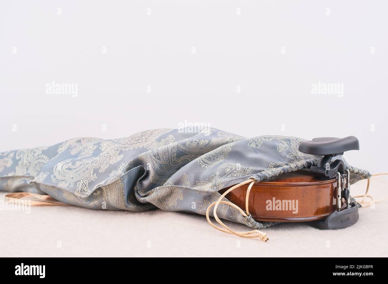 Akustische Geige in einer Seidentasche auf einem weißen Schreibtisch mit Platz für Text Stockfoto