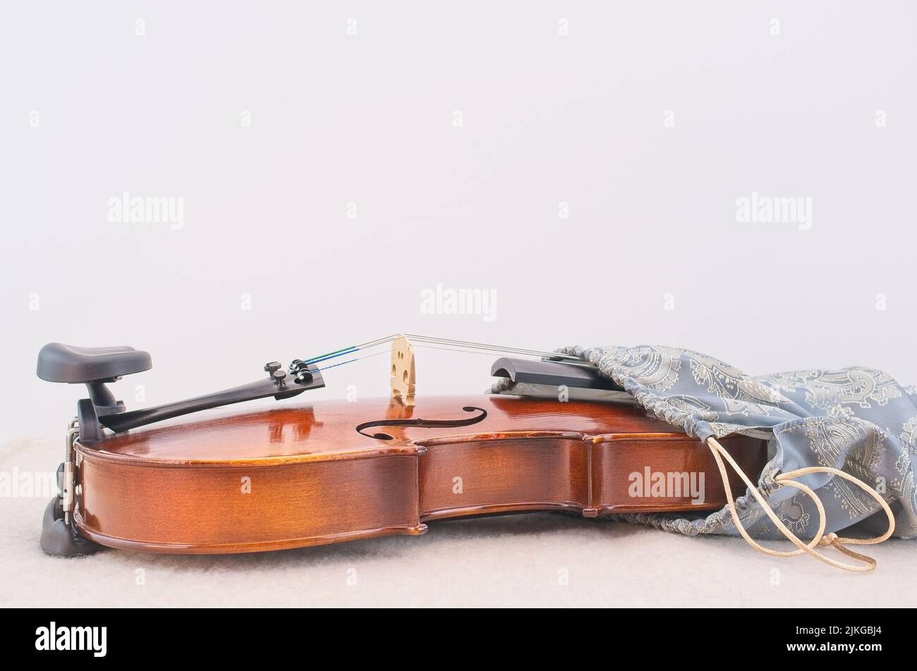 Akustische Geige in einer Seidentasche auf einem weißen Schreibtisch mit Platz für Text Stockfoto