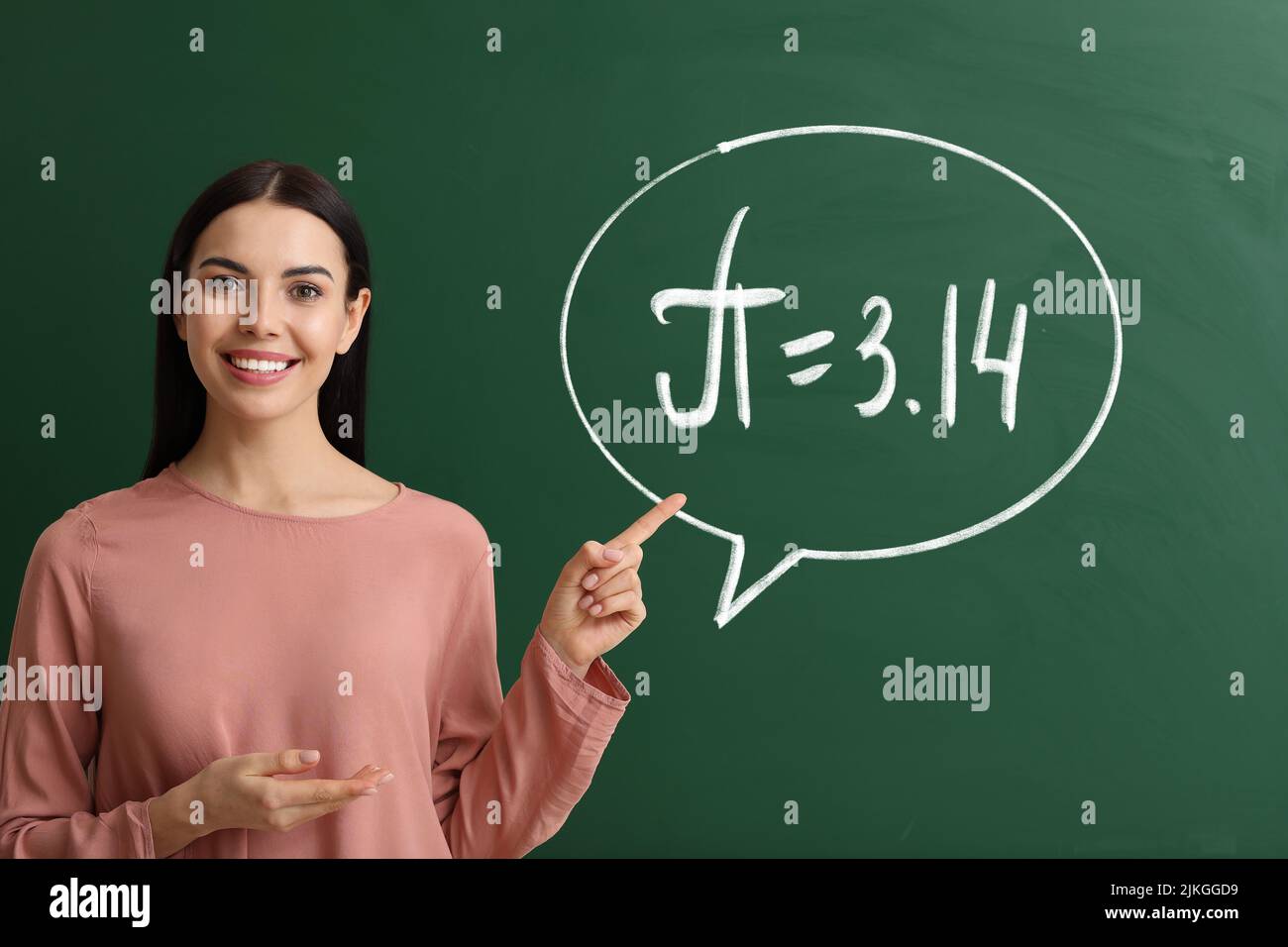 Lehrerin in der Nähe der Tafel mit der schriftlichen Nummer Pi Stockfoto