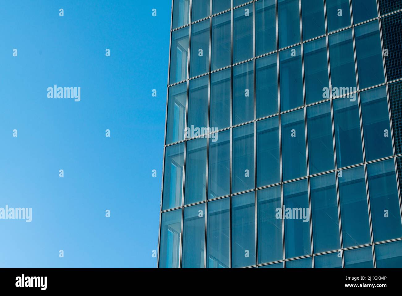 Besonderer Wolkenkratzer: Architektur eines Gebäudes mit einer komplett verglasten Fassade, mit Elementen aus Fenstern und durchgehender Verglasung. Stockfoto