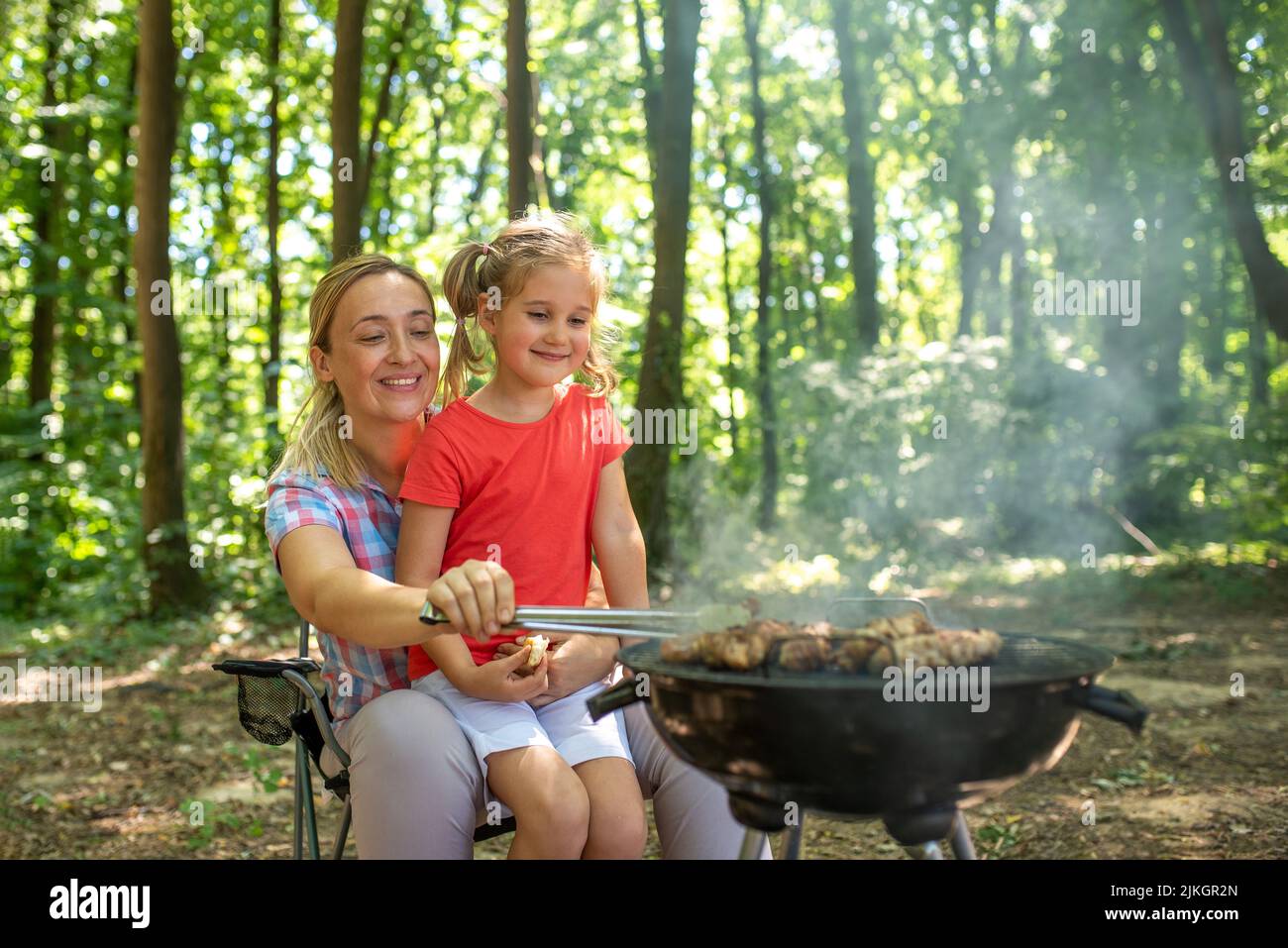 Eine glückliche Mutter und Tochter beim Grillen in der Natur Stockfoto