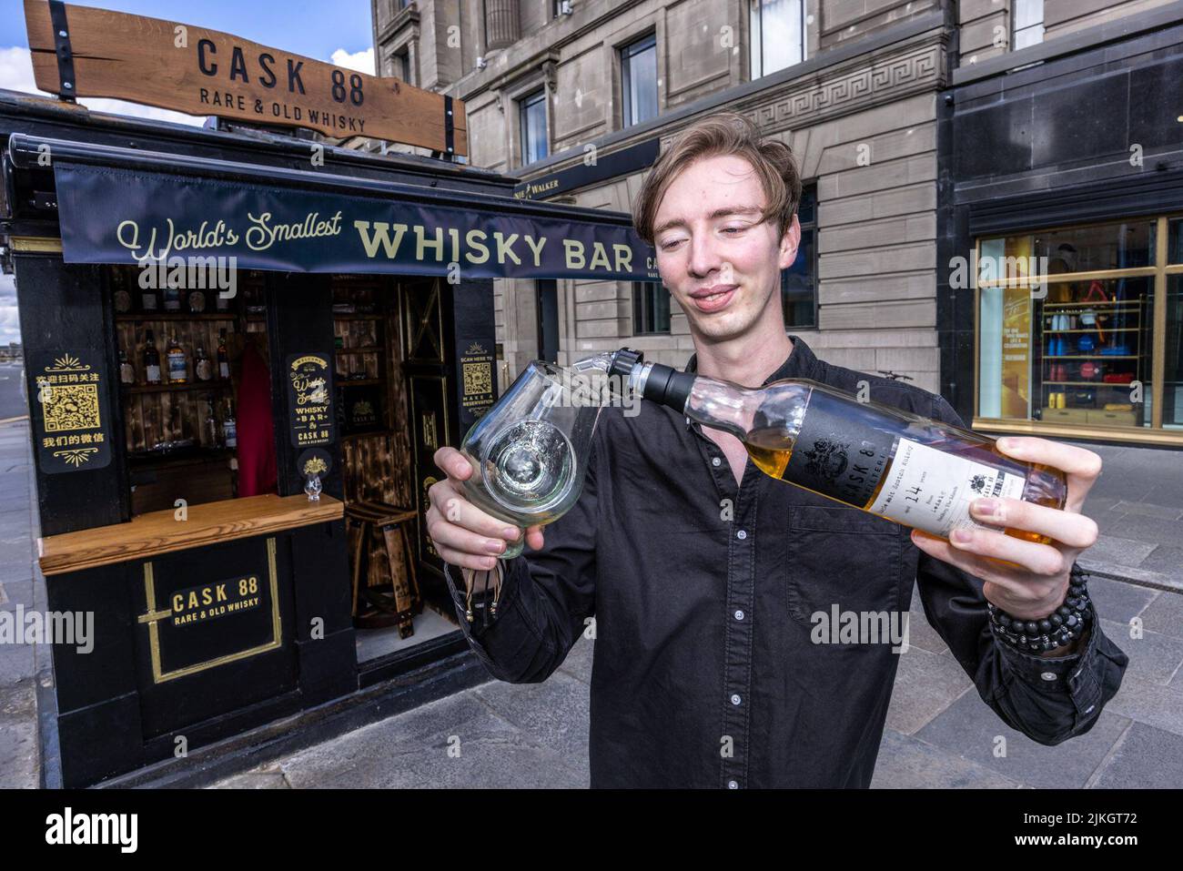 Edinburgh, Großbritannien. 02. August 2022 im Bild: L to R Barman, Mark Young vor der kleinsten Whisky Bar der Welt. Der unabhängige Whisky-Abfüller Cask 88 hat im Rahmen des Edinburgh Fringe Festivals die weltweit kleinste Whisky-Bar in Edinburgh eingerichtet. Der Barkeeper bietet Platz für einen Gast und serviert eine Auswahl an Drams aus der Cask 88 Range. Quelle: Rich Dyson/Alamy Live News Stockfoto