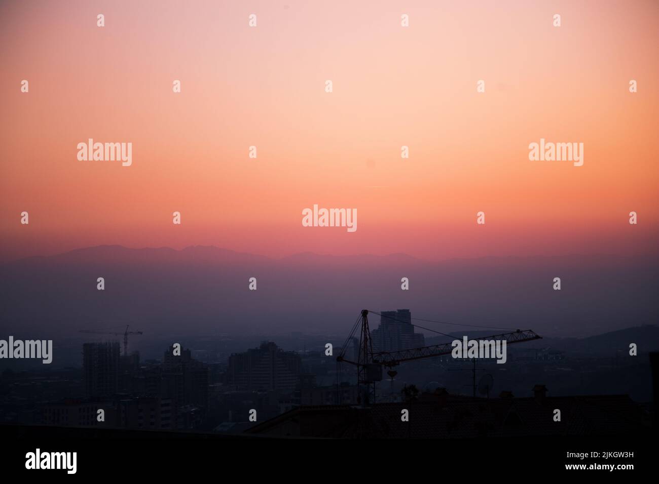 Ein Blick auf eine Stadt bei dem wunderschönen orange-violetten Sonnenuntergang Stockfoto