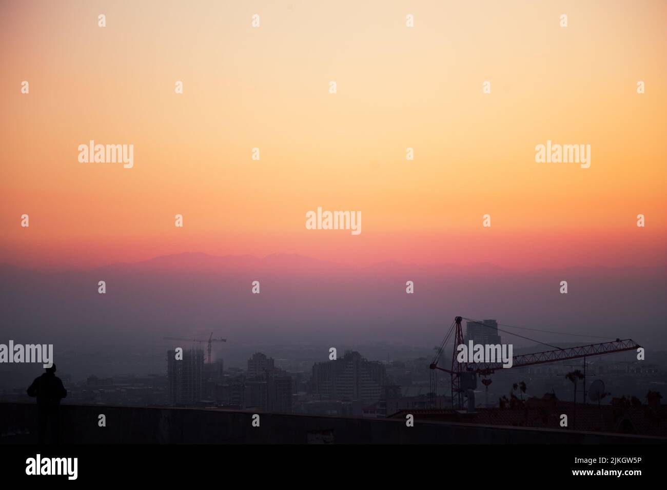 Ein Blick auf eine Stadt bei dem wunderschönen orange-violetten Sonnenuntergang Stockfoto