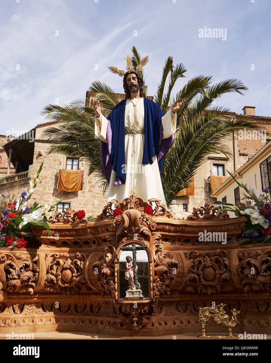 Eine vertikale Aufnahme von Jesus Christus Skulptur gegen Palmen während der Passionswoche in Plasencia. Spanien. Stockfoto