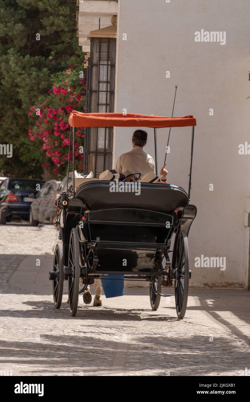 ronda, malaga, spanien 20. juni 2022 Rückansicht von Touristen in einer Pferdekutsche, die die Stadt besuchen. Stockfoto