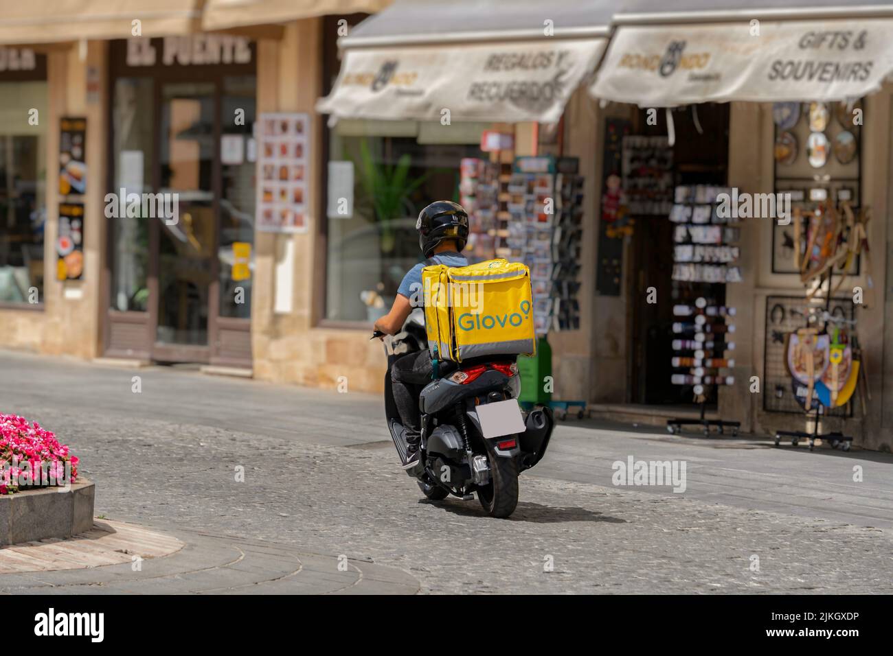 ronda, malaga, spanien 20. juni 2022 Rückansicht eines jungen Glovo-Lieferers auf einem Motorrad in der Stadt Stockfoto
