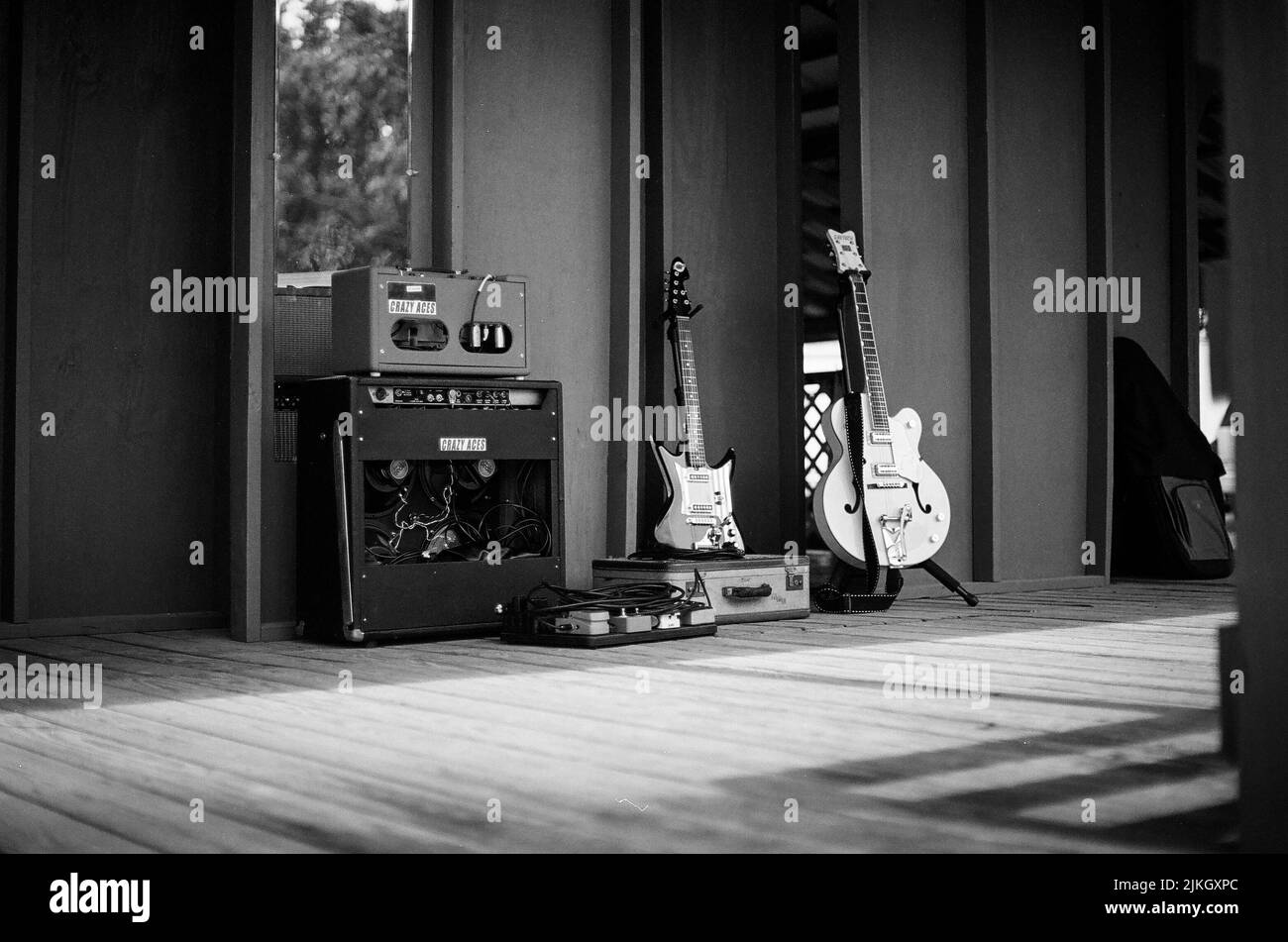 Eine Graustufenaufnahme von Gitarren und Amp-Ausrüstung auf einer Bühne Stockfoto