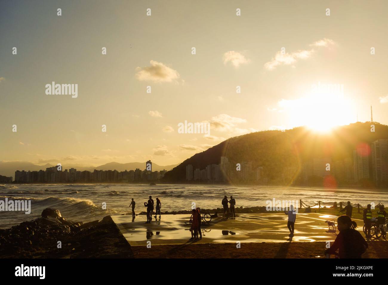 Santos, Brasilien: Menschen, die Spaß am Meer bei Sonnenuntergang haben. Reise- und Sommerkonzept Stockfoto