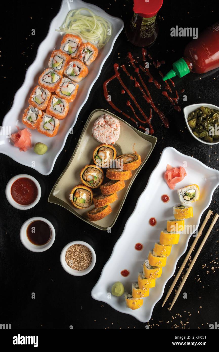 Ein Sushi-Set mit Saucen von oben auf einem schwarzen Tisch Stockfoto