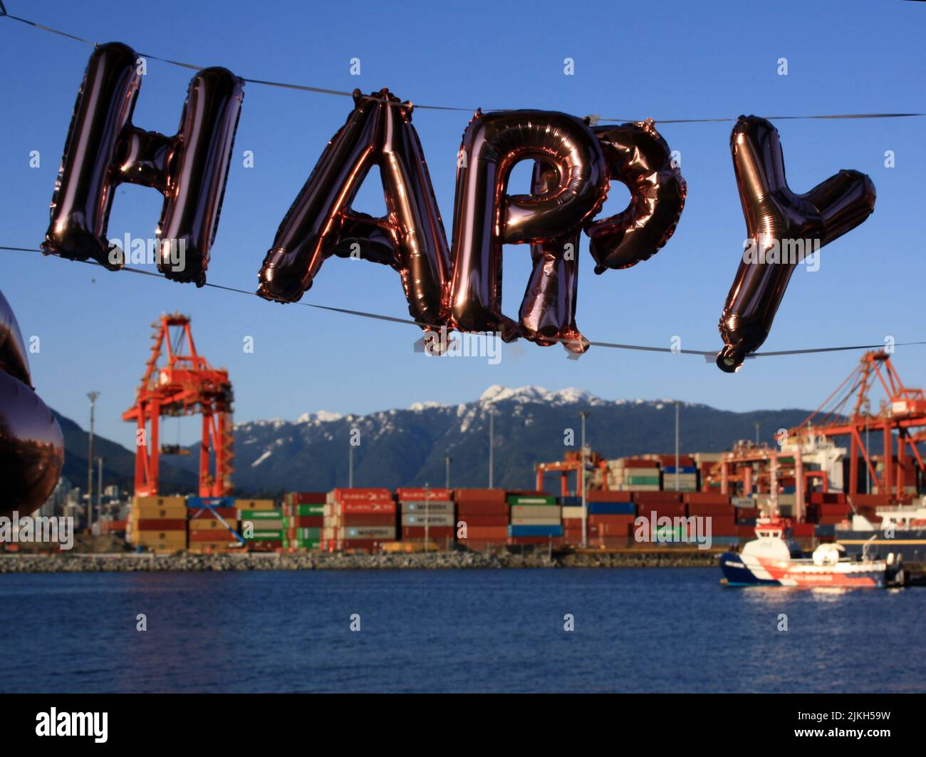 Die Briefe GLÜCKLICH mit dem Hafen von Vancouver im Hintergrund. British Columbia, Kanada Stockfoto Die Briefe GLÜCKLICH mit dem Hafen von Vancouver im Hintergrund. British Columbia, Kanada Stockfoto