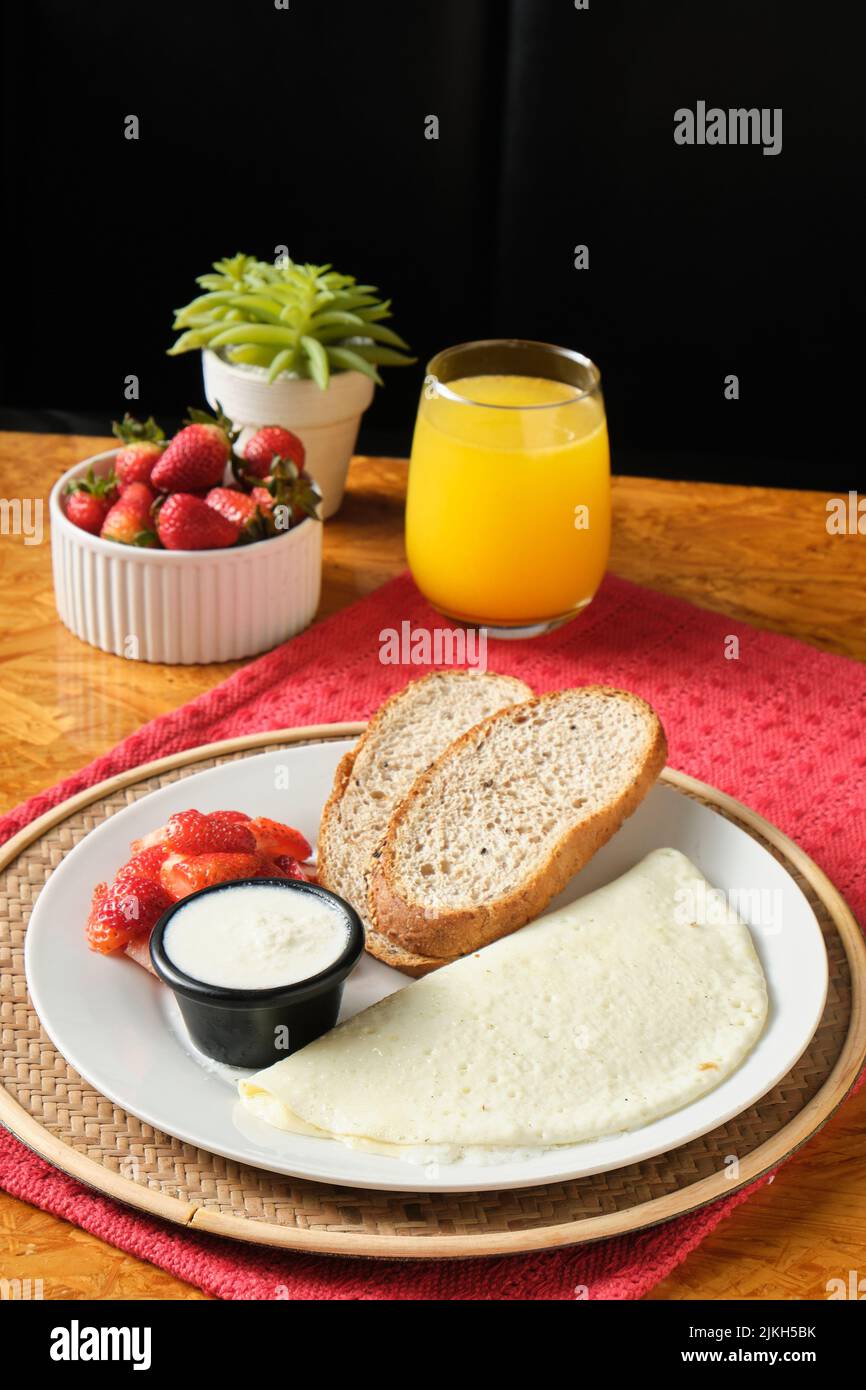 Eine vertikale Nahaufnahme eines gesunden Frühstücks mit Eiweiß, Brot und Erdbeere Stockfoto