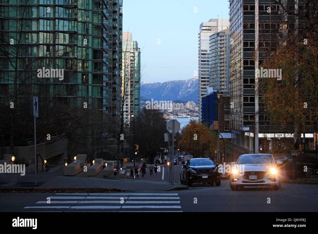 Das Auto mit einem Licht an in der Winterdämmerung auf der Straße der Innenstadt von Vancouver, British Columbia, Kanada Stockfoto