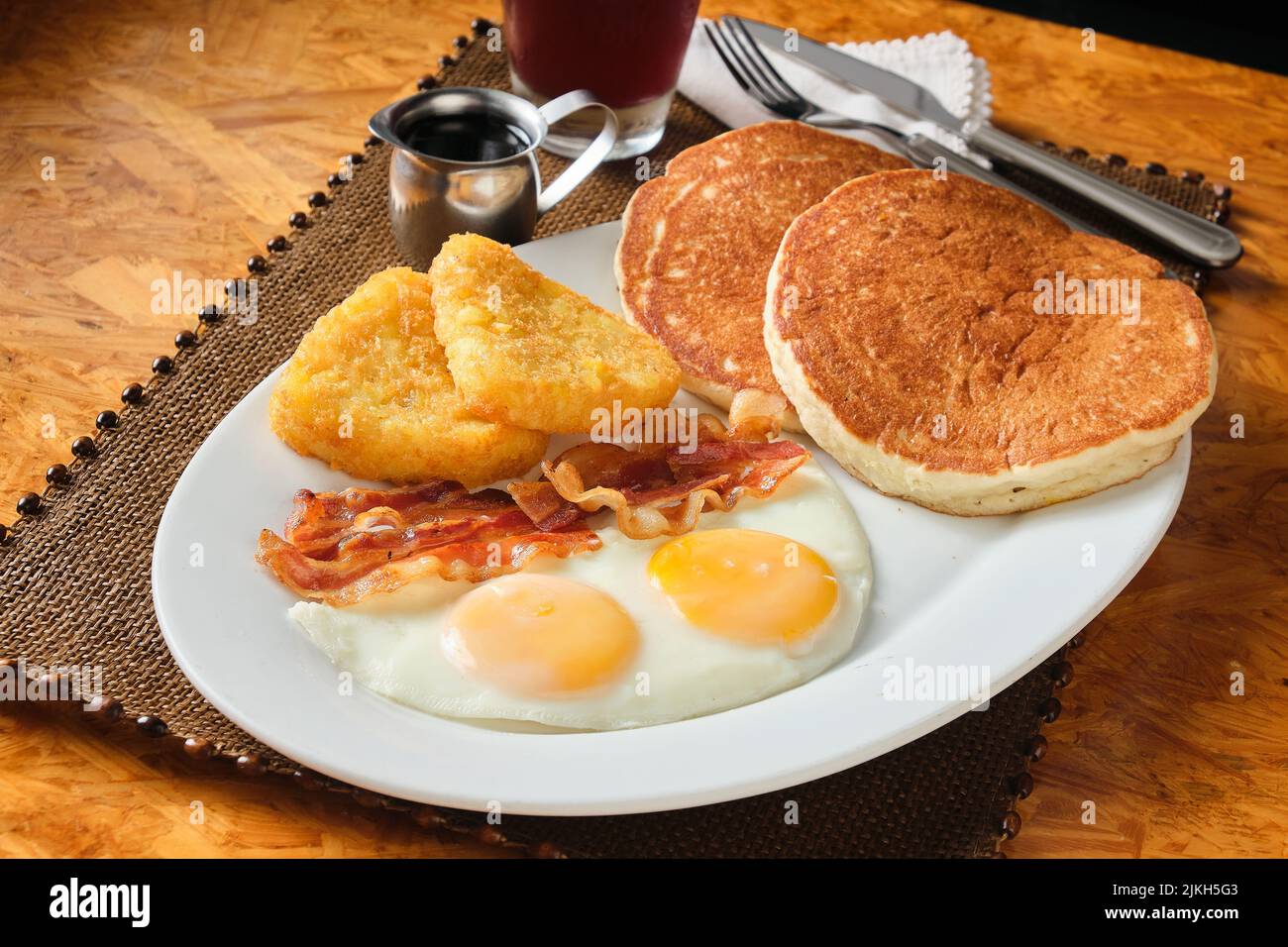 Ein Nahaufnahme eines amerikanischen Frühstücks mit Pfannkuchen, Speck, Eiern und Hashbraun Stockfoto