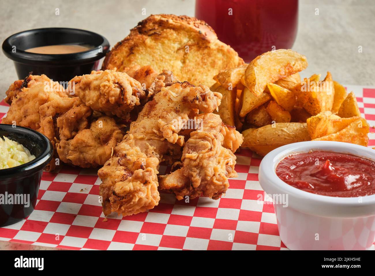 Eine Nahaufnahme von Hähnchenfingern, serviert mit Pommes Frites und Saucen Stockfoto