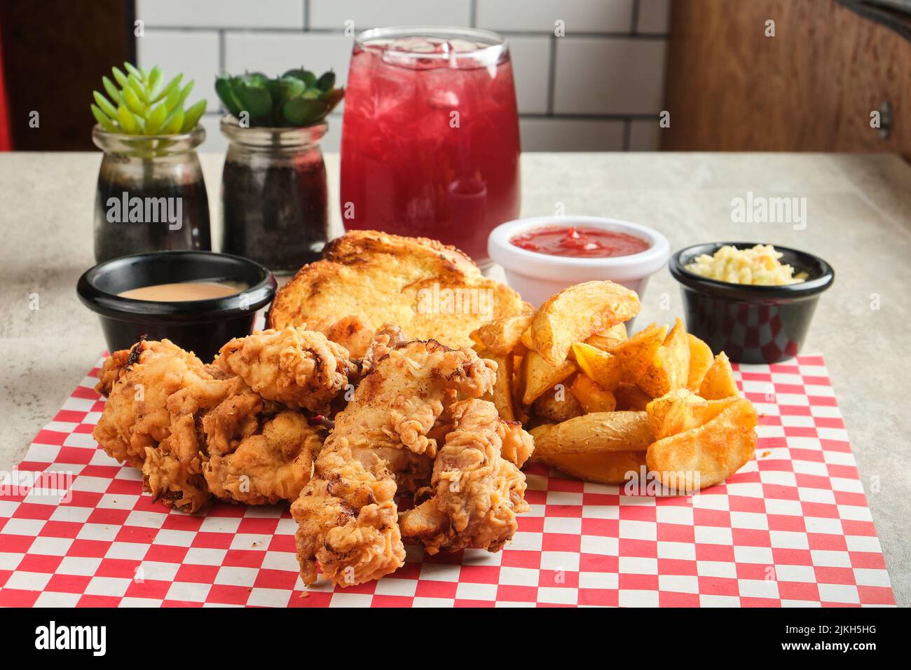 Eine Nahaufnahme von Hähnchenfingern, serviert mit Pommes Frites und Saucen Stockfoto