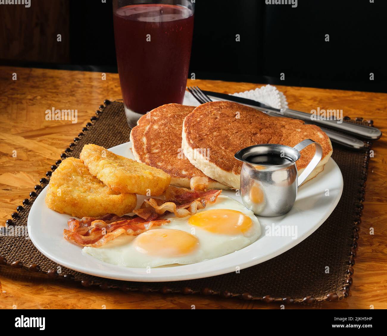 Ein Nahaufnahme eines amerikanischen Frühstücks mit Pfannkuchen, Eiern, Speck und Hashbraun Stockfoto