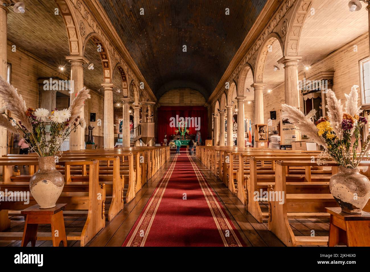 Die Menschen am Altar einer schönen Kirche mit rotem Teppich und Bänken in Chonchi, Chiloe, Chile Stockfoto