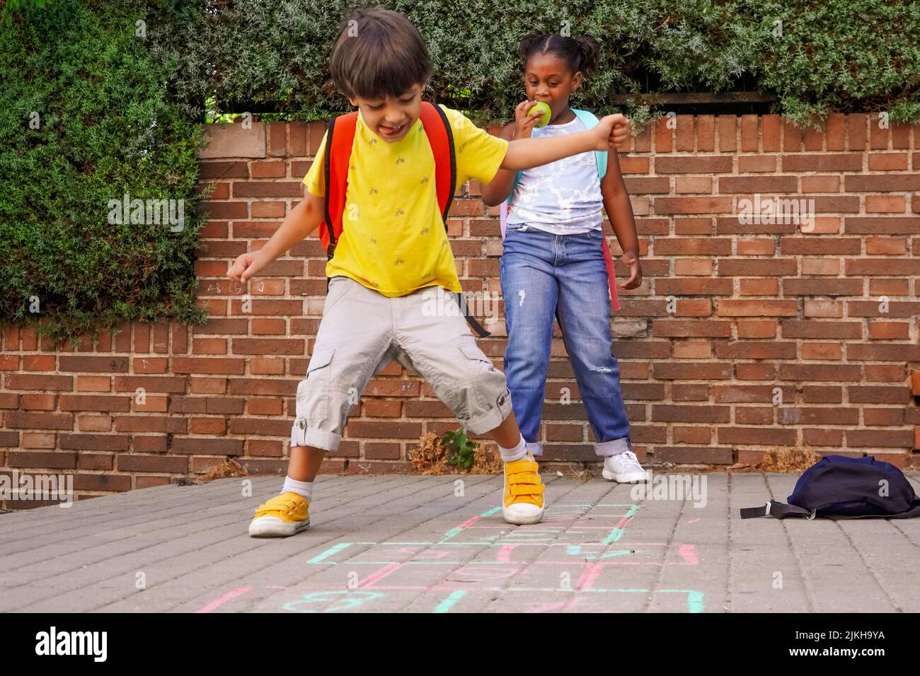 Multiethnische Kinder spielen hopscotch auf dem Schulhof. Zurück zum Schulkonzept. Multiethnische Kindergruppe Stockfoto