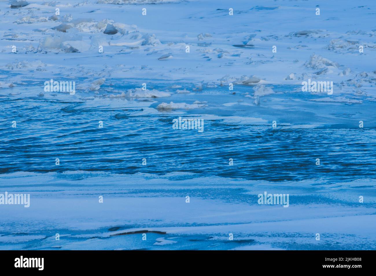 Eine Textur aus blauem Wellenwasser mit Eisstücken Stockfoto