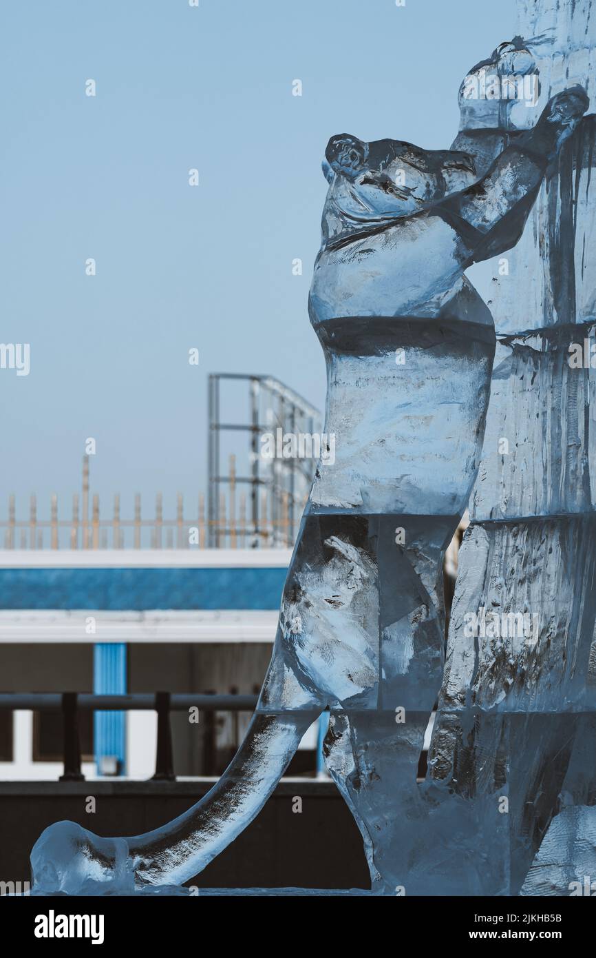 Eine vertikale Aufnahme einer Eisskulptur eines Tigers, der unter einem blauen Himmel in China steht Stockfoto