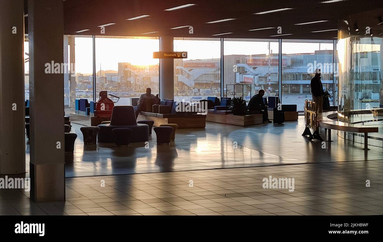 Die Silhouetten der Menschen auf dem Amsterdamer Flughafen Schiphol bei Sonnenaufgang Stockfoto