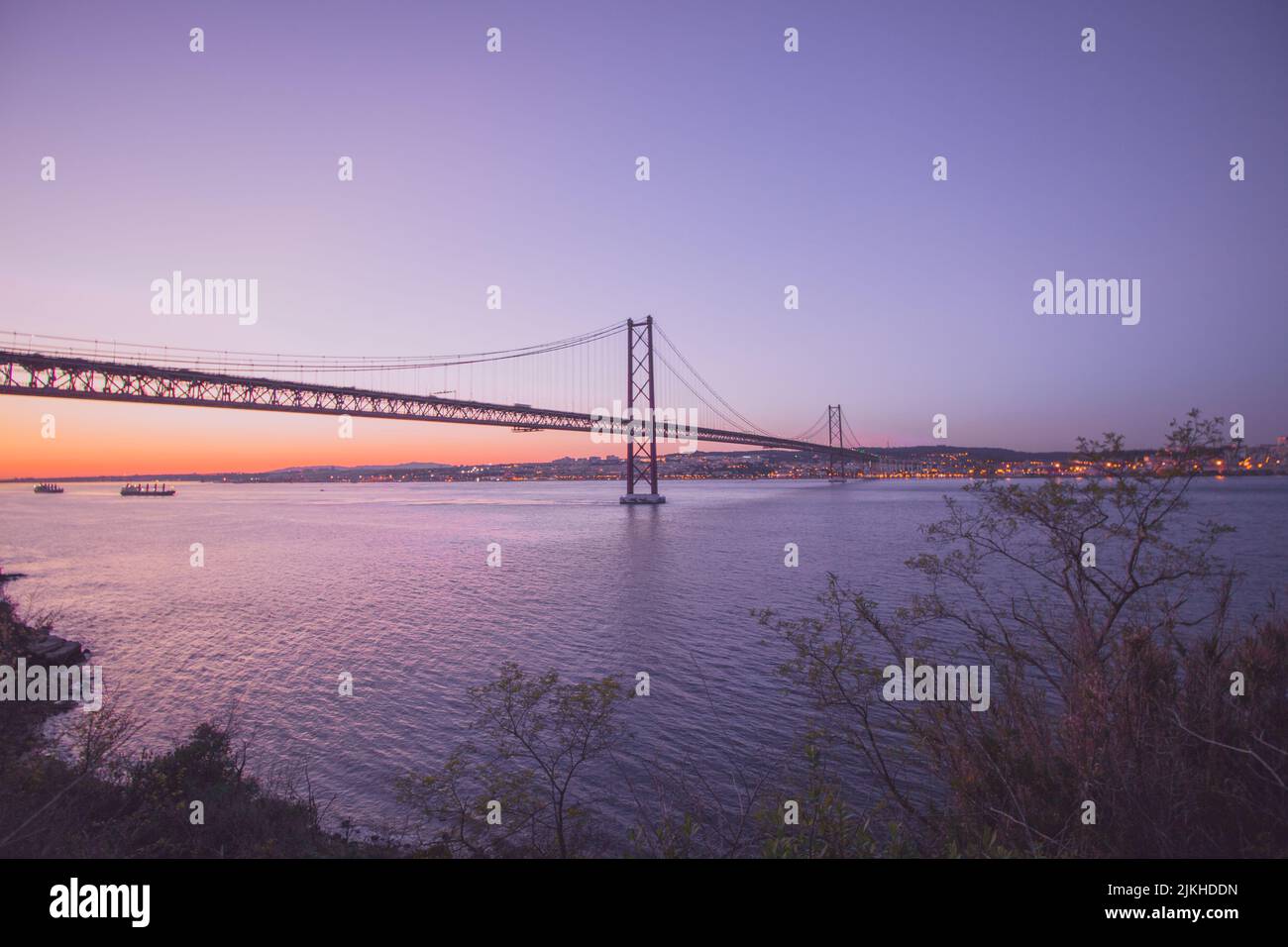 Ein schöner Blick auf die Hängebrücke Ponte 25 de Abril in Portugal bei Sonnenuntergang Stockfoto