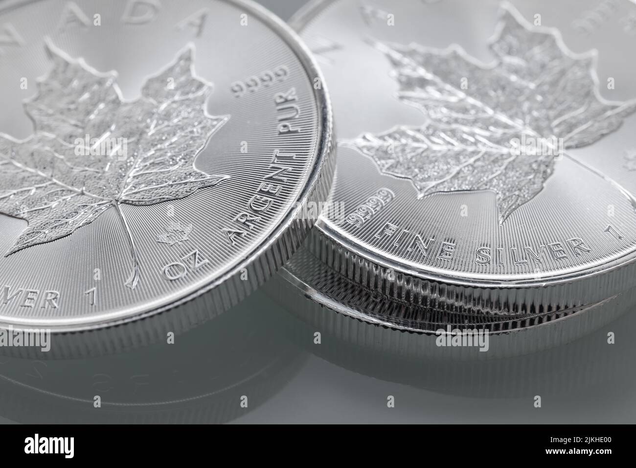 Eine Nahaufnahme eines Stapels von 1oz Silver Canadian Maple Leaf auf grauem Hintergrund Stockfoto