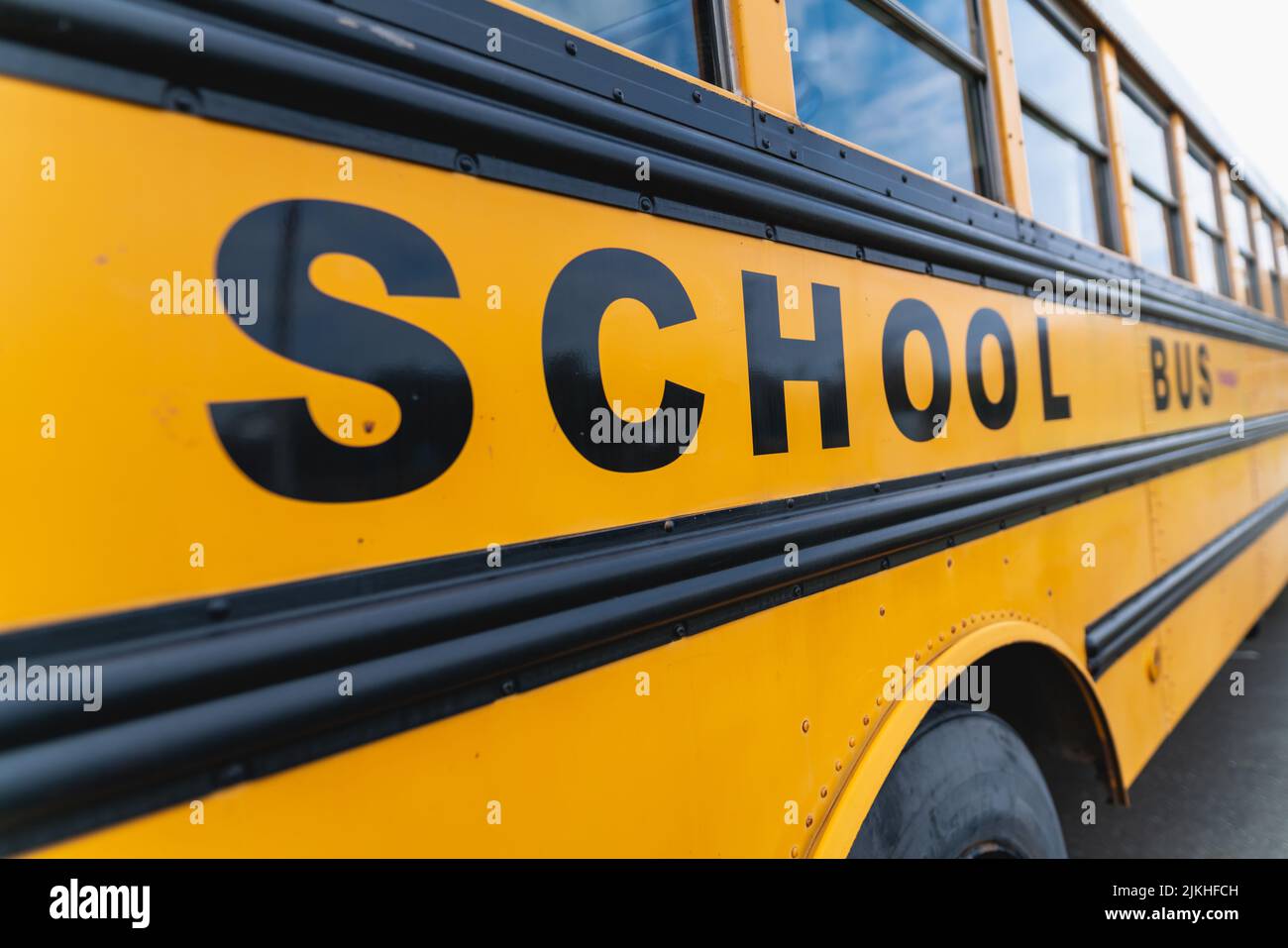 Eine Nahaufnahme des gelben klassischen Schulbusses. Seitenansicht. Amerikanische Bildung. Stockfoto