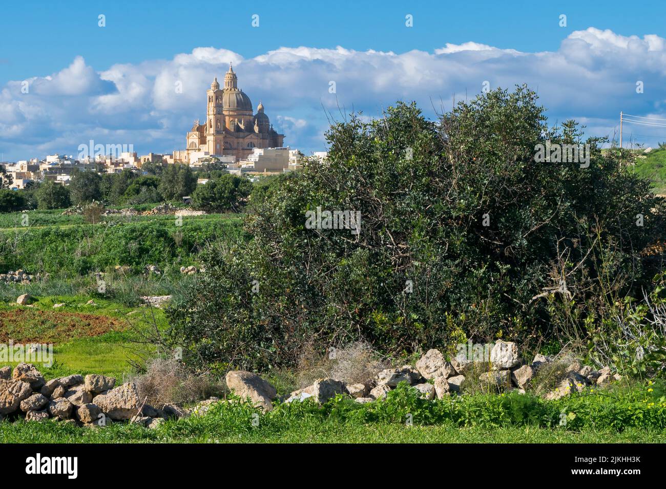 Landschaftsaufnahme der Landschaft in der Nähe des Dorfes Xewkija, Gozo, Malta, dominiert von der katholischen Kirche, die dem heiligen Johannes dem Täufer geweiht ist. Stockfoto