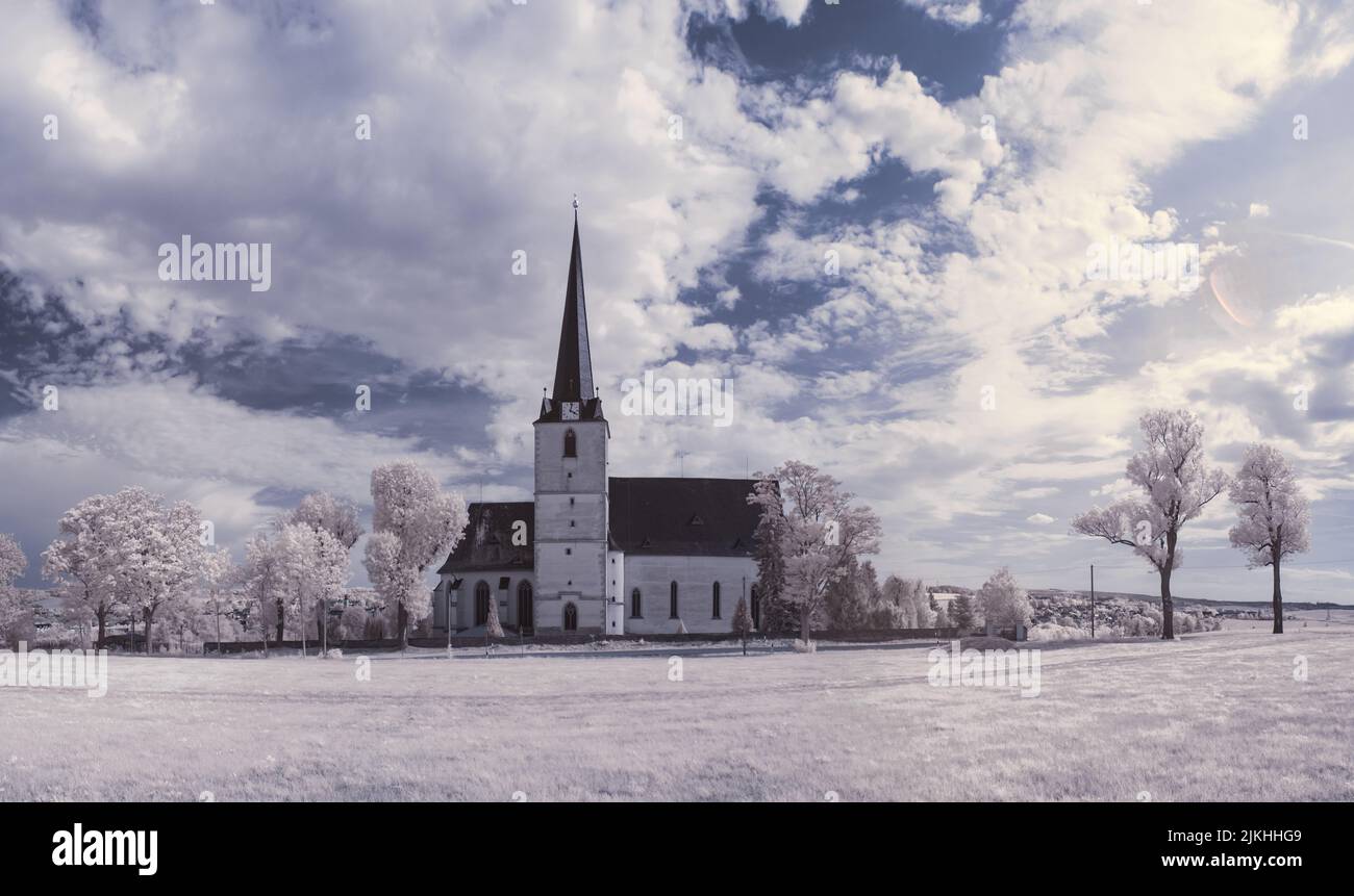 Blick auf eine Kirche auf dem schneebedeckten Feld im Winter Stockfoto
