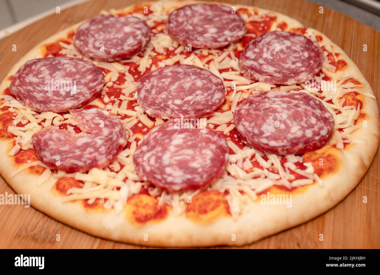 Pepperoni Pizza mit Mozzarella-Käse, Salami, Tomaten, Pfeffer, Gewürzen und frischem Basilikum. Italienische Pizza Stockfoto