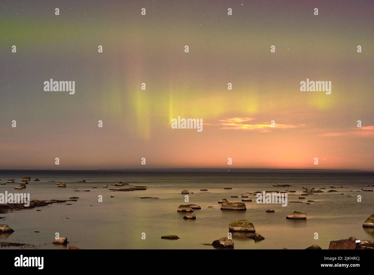 Ein einzigartiges Naturphänomen sind die Nordlichter (Aurora Borealis), die über einem ruhigen See tanzen und sich im Wasser spiegeln Stockfoto