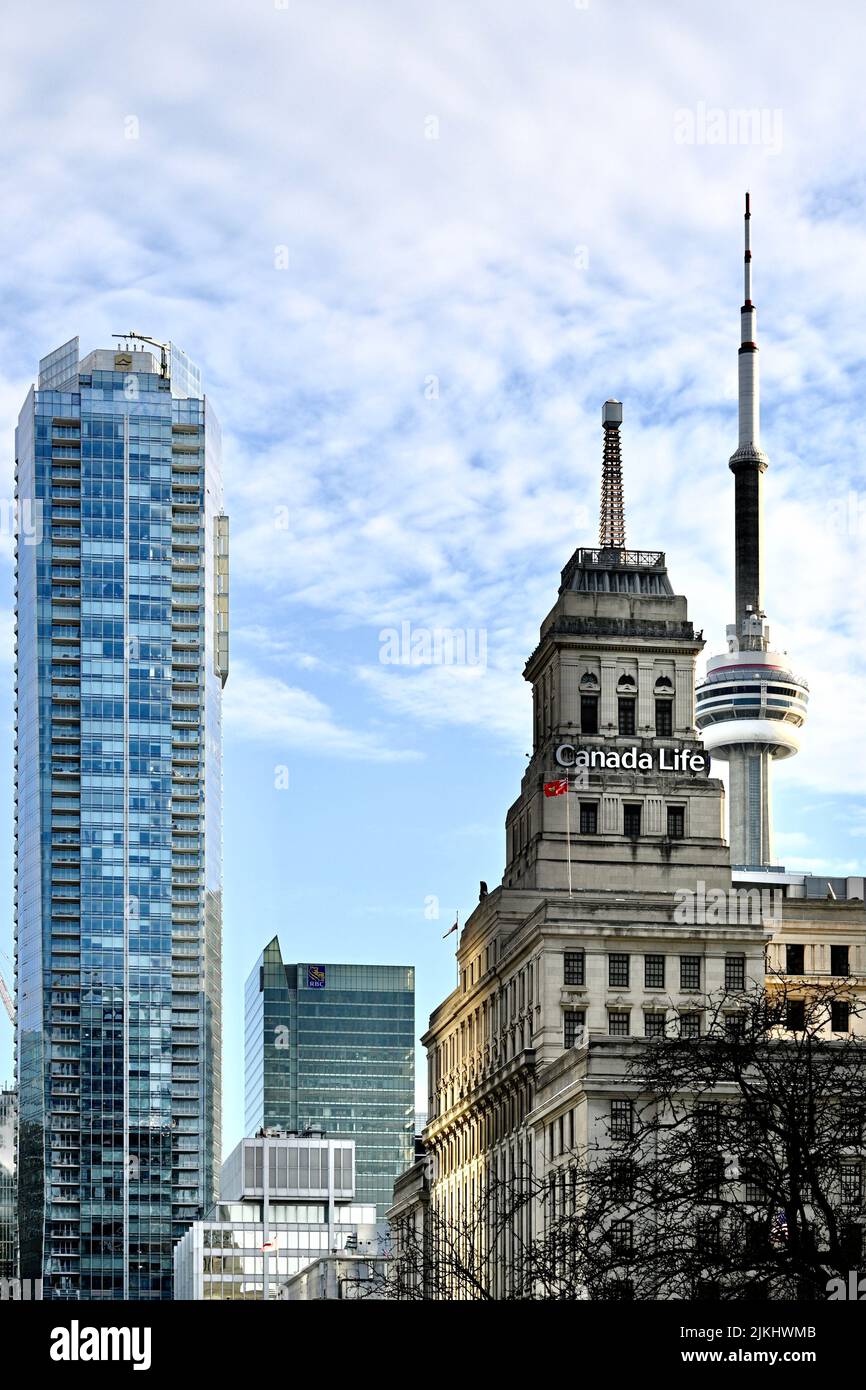 Eine vertikale Aufnahme des Canada Life-Gebäudes und des CN-Turms im wolkigen Hintergrund Stockfoto
