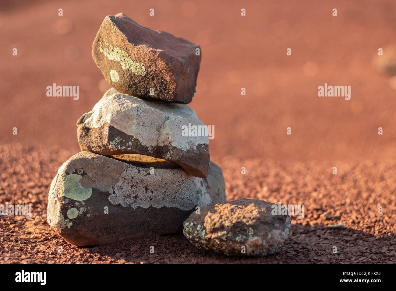 Eine Nahaufnahme von Steinen, die auf dem roten Boden übereinander gestapelt sind. Ausgewählter Fokus. Stockfoto