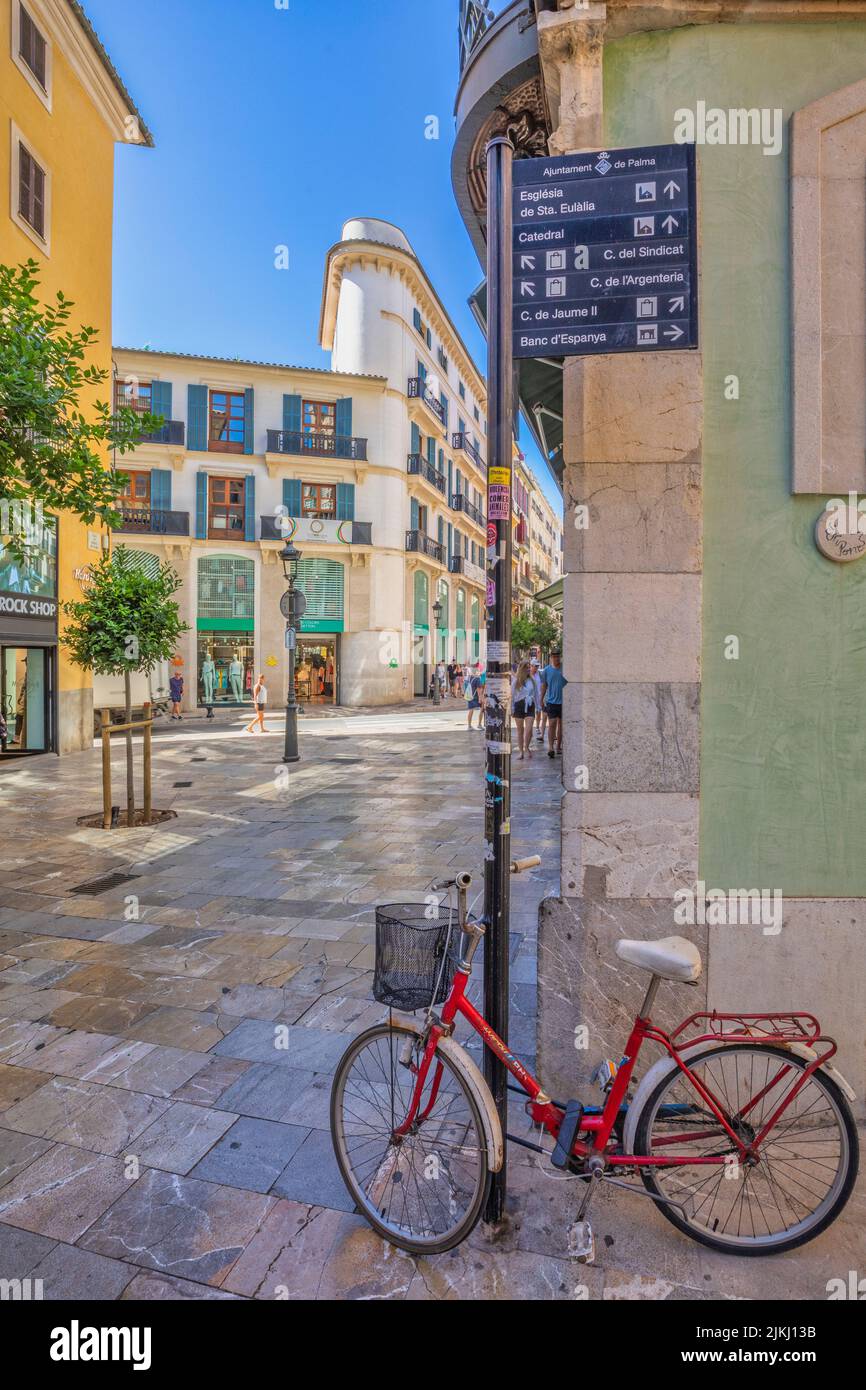 Spanien, Balearen, Mallorca, Palma. Straßen in Palma de Mallorca, rotes Fahrrad an einer Stange im historischen Zentrum gebunden Stockfoto