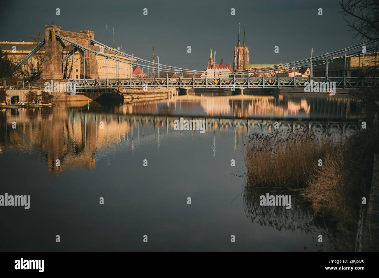Die Odra reflektiert die Breslauer Stadtgebäude und blattlose Bäume auf dem Wasser. Stockfoto