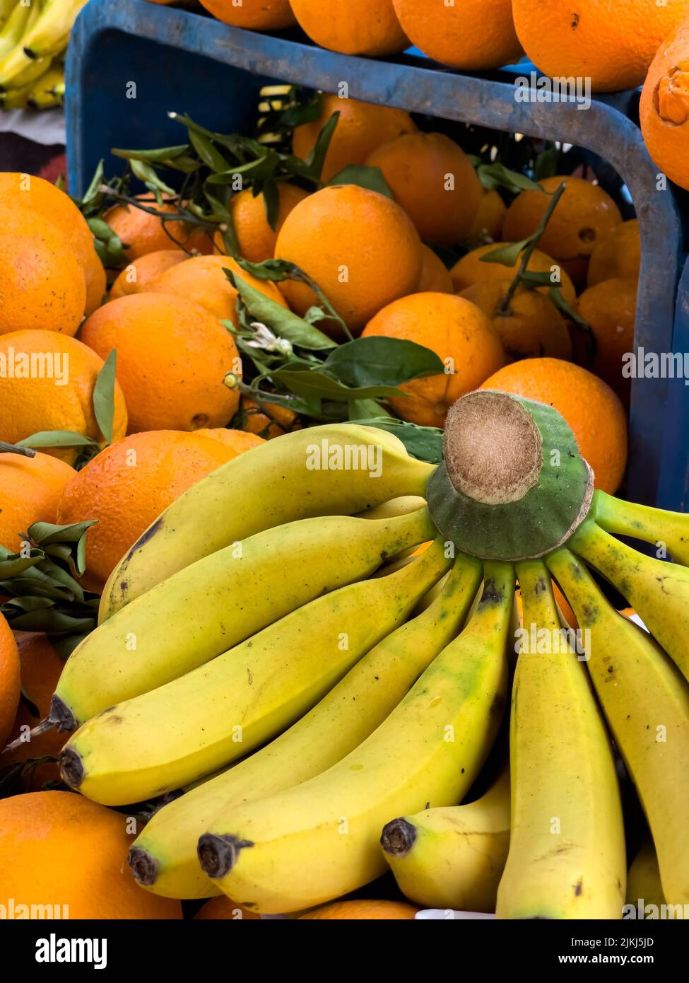 Nahaufnahme eines Stapels frischer Orangen und Bananen auf einem Straßenmarkt im Freien Stockfoto